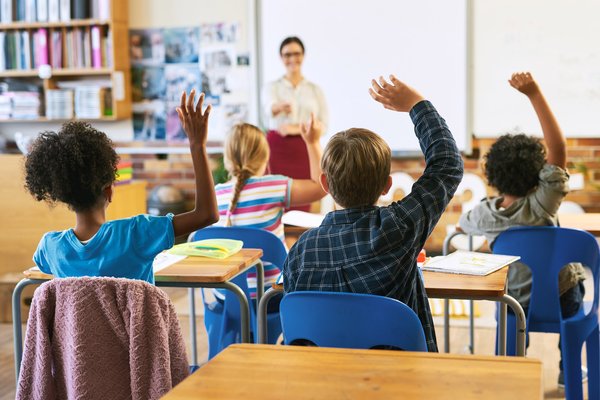 Kinder melden sich im Unterricht