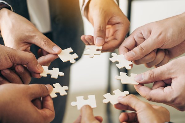 Hände halten Puzzlestücke