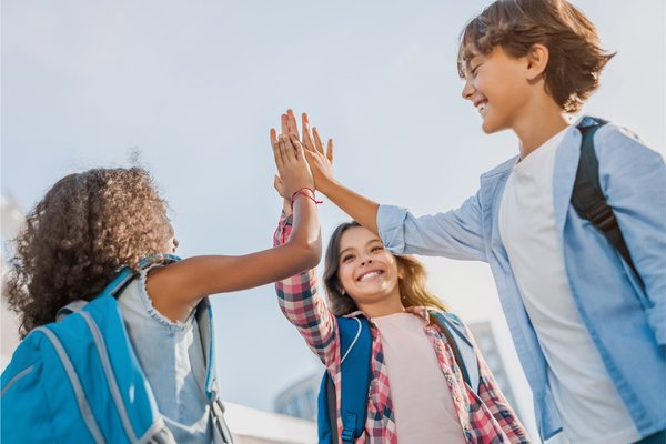 drei Kinder klatschen sich ab